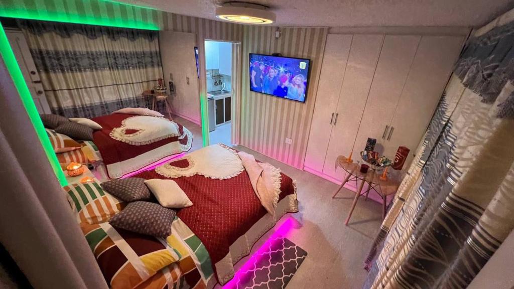 una camera con due letti e una TV a schermo piatto di Gold House Oro a Quito