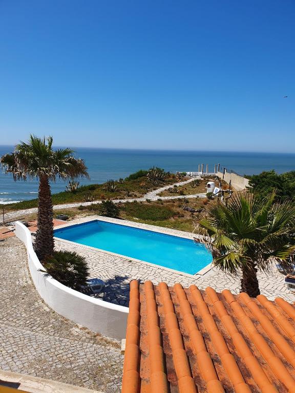 a swimming pool with a view of the ocean at Vila Vistazul in Pataias
