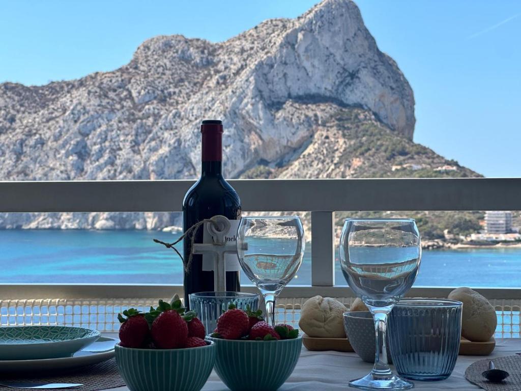 a table with a bottle of wine and two glasses at Apartamentos Horizonte Estudio (8º-801) in Calpe