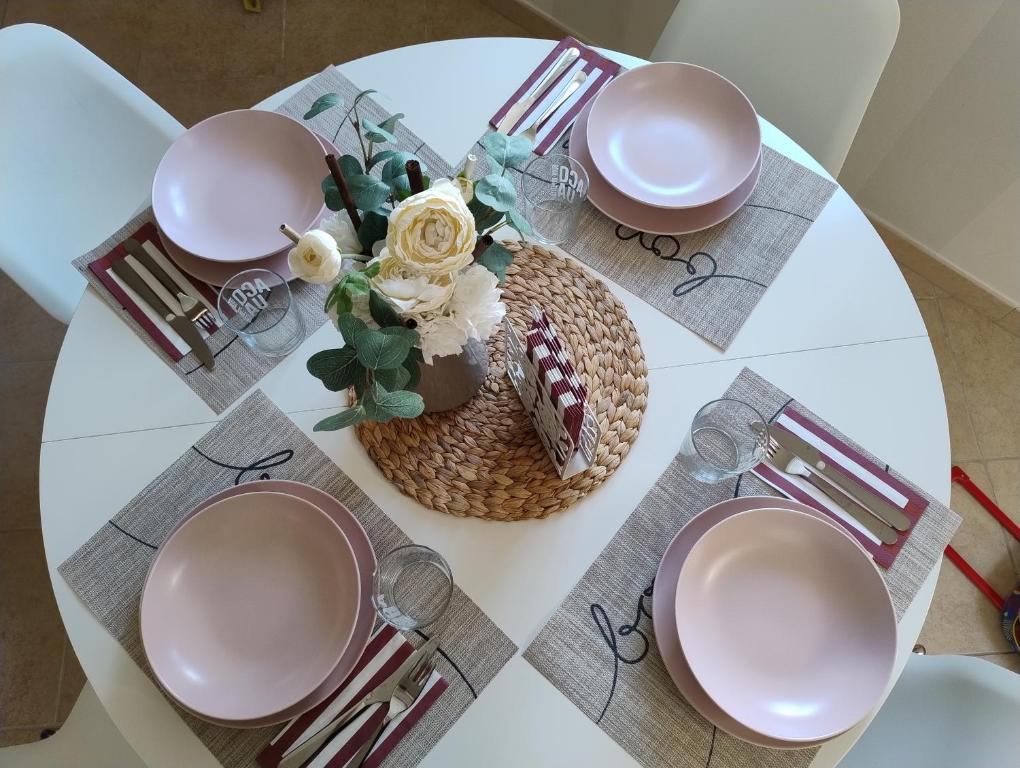 a table with plates and a vase with flowers on it at Il Cantuccio in Sestri Levante