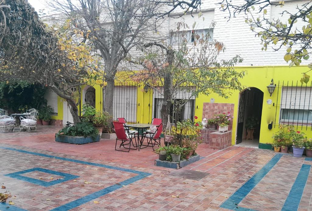 a yellow house with a patio with a table and chairs at Departamento amplio a metros del mar in Puerto Madryn
