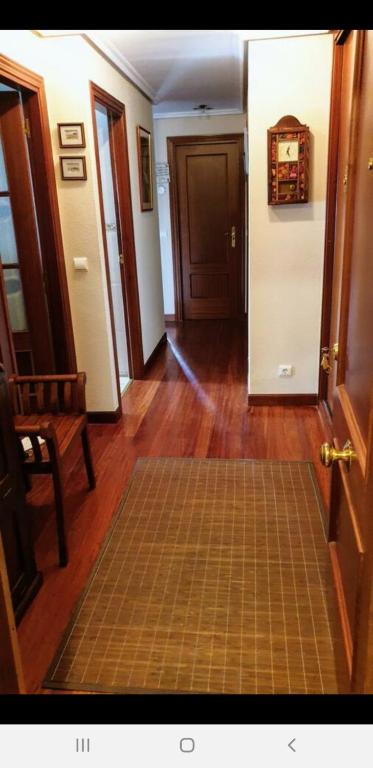 a hallway with a door and a rug on the floor at Castro Urdiales in Castro-Urdiales