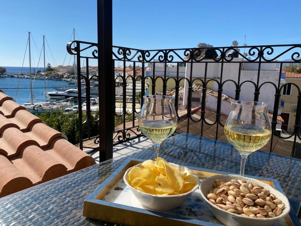 un tavolo con due bicchieri di vino e un vassoio di cibo di Manus Dei Exclusive Suites a Pythagóreion
