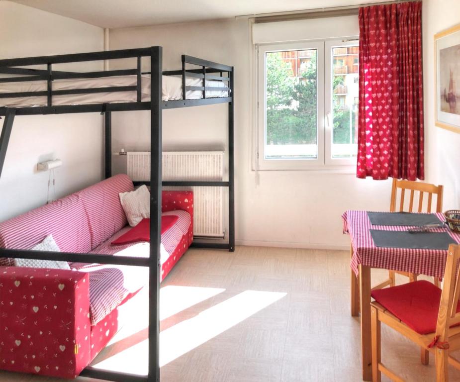 - un salon avec des lits superposés et une table dans l'établissement Studio avec wifi a Le Devoluy, à Saint-Étienne-en-Dévoluy