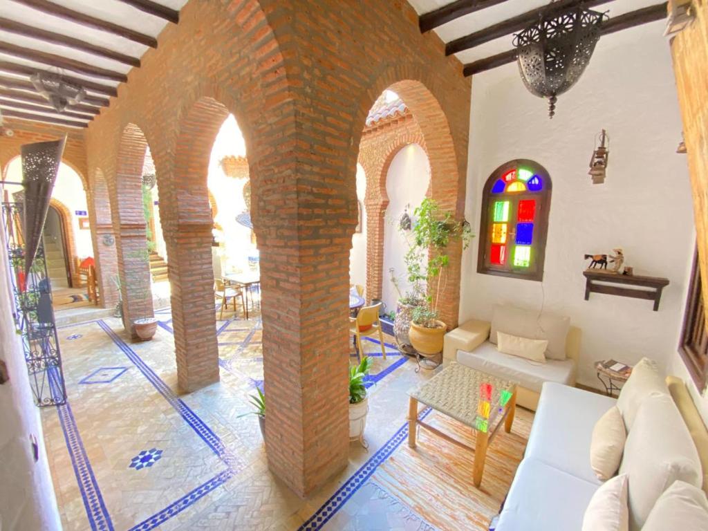 Elle comprend un salon avec des plafonds voûtés et un mur en briques. dans l'établissement Riad Gharnata, à Chefchaouen
