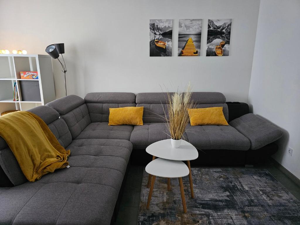a living room with a gray couch with yellow pillows at Warburg FeWo "Sweet Home" 2,5 Zi, EG, separater Eingang, 82mq in Warburg