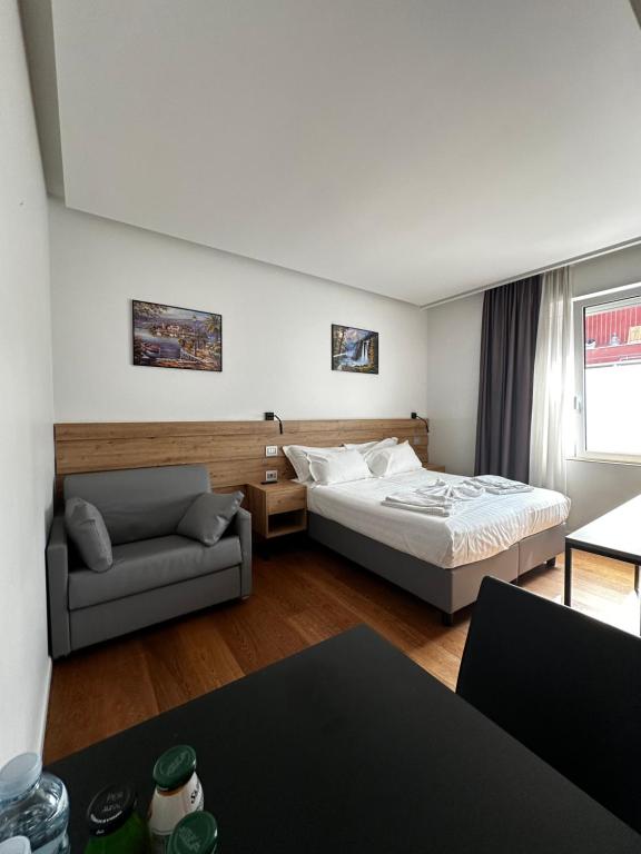 a hotel room with a bed and a couch at Grandi 32 in Segrate
