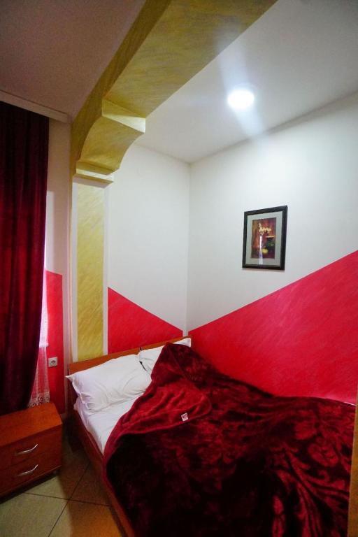 a bedroom with a red and white wall at Apartmani Lazić in Gracanica