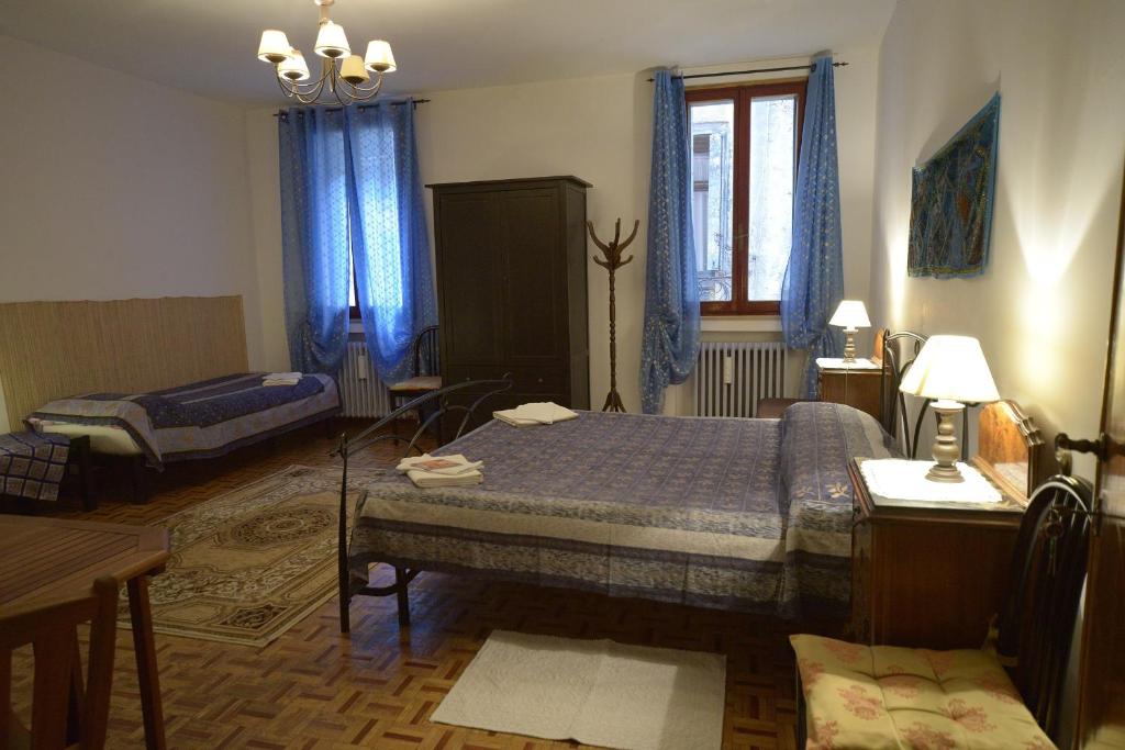 sypialnia z 2 łóżkami, stołem i biurkiem w obiekcie B&B Arabesque w Wenecji