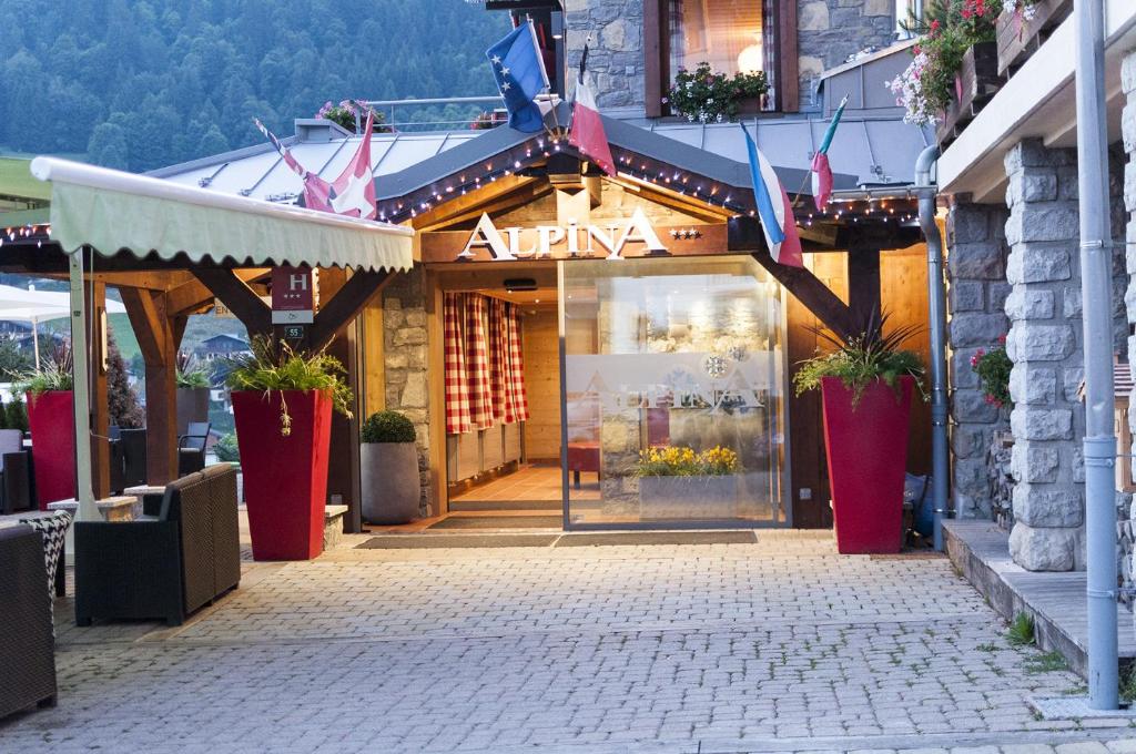 an entrance to a store in a street with flags at Hôtel Alpina &amp; SPA in Les Gets