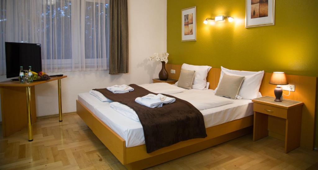 ein Hotelzimmer mit einem Bett mit Handtüchern darauf in der Unterkunft Garni Hotel Rödelheimer Hof in Frankfurt am Main