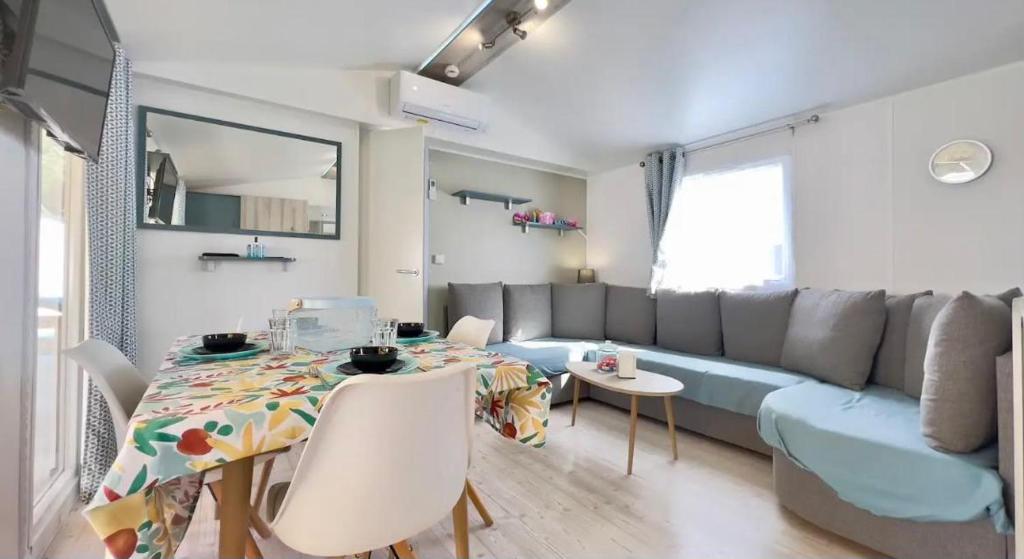 un salon avec un canapé bleu et une table dans l'établissement CAMPING Siblu Le Montourey - LE FARNIENTE, à Fréjus
