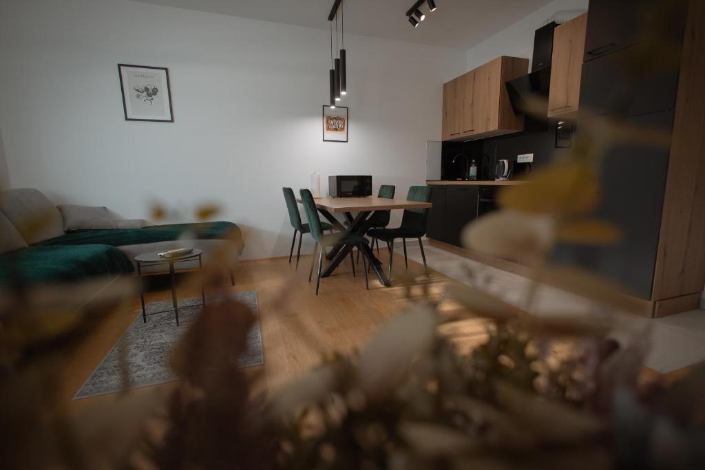 ein Wohnzimmer und eine Küche mit einem Tisch und Stühlen in der Unterkunft Lega Donji Grad Self check in, private Parking in Osijek