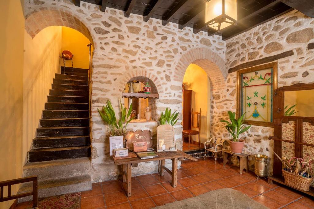 um quarto com uma escada e uma parede de pedra em Casa Rural Churruca em Jaraiz de la Vera