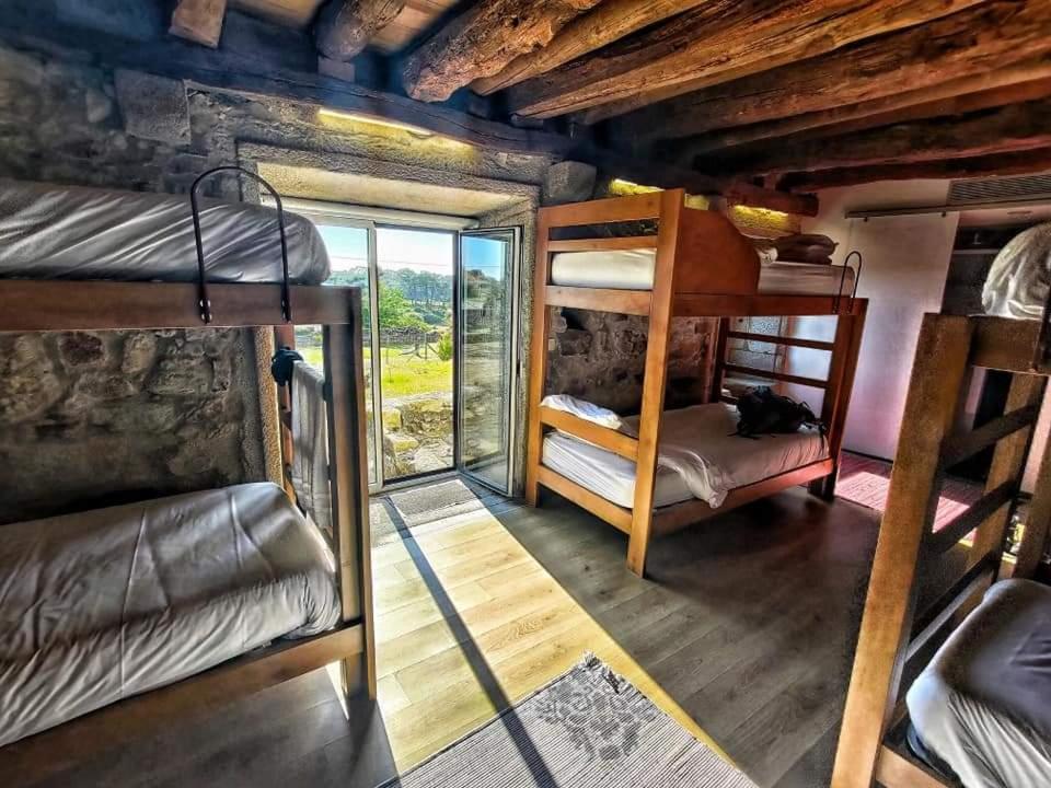 Habitación con 3 literas y ventana. en Albergue Casa do Sardão, en Carreço