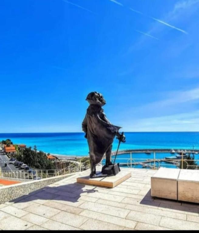 a statue of a woman standing on a ledge overlooking the ocean at Casa Eden in Ventimiglia