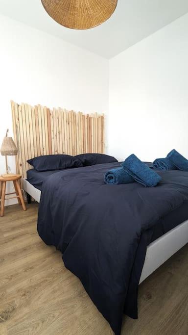 une chambre avec un lit avec une couette bleue dans l'établissement Les voisins de l'hippodrome, à Pornichet