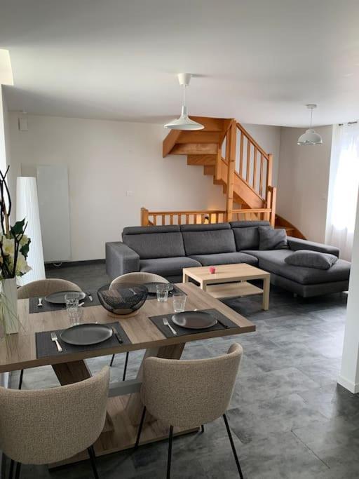 un salon avec un canapé, une table et des chaises dans l'établissement Le Dauphiné, à Mortagne-sur-Sèvre