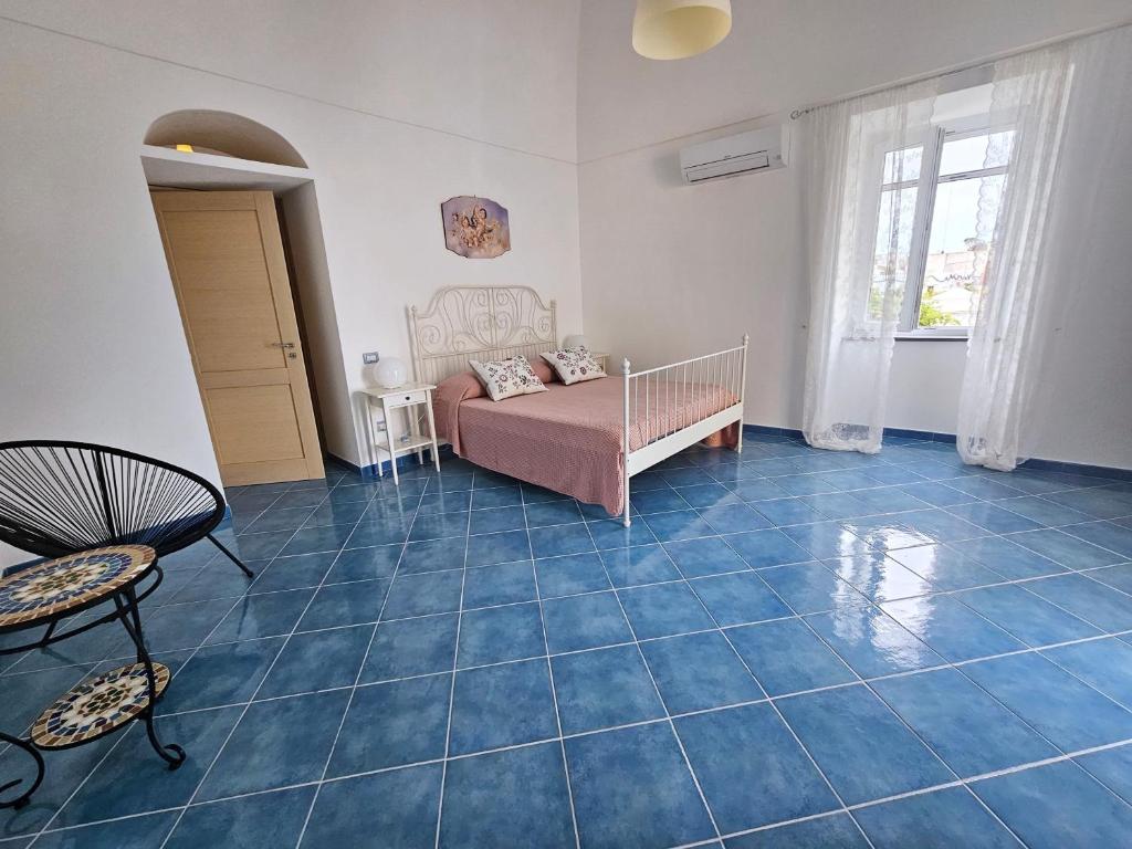 a living room with a bed and a blue tile floor at Maridea - Marlin in Ponza