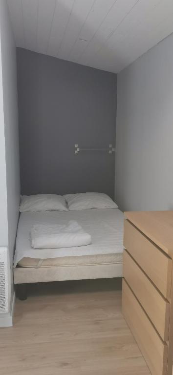 - une petite chambre avec un lit et une commode dans l'établissement Chez Sophie et Anne Lise, à Bourcefranc
