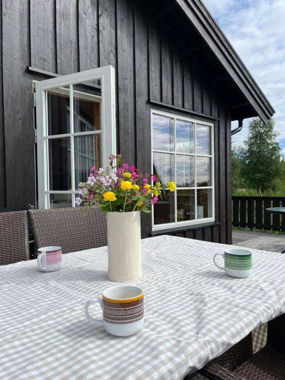 una mesa con un jarrón de flores. en Beautiful cabin close to activities in Trysil, Trysilfjellet, with Sauna, 4 Bedrooms, 2 bathrooms and Wifi en Trysil