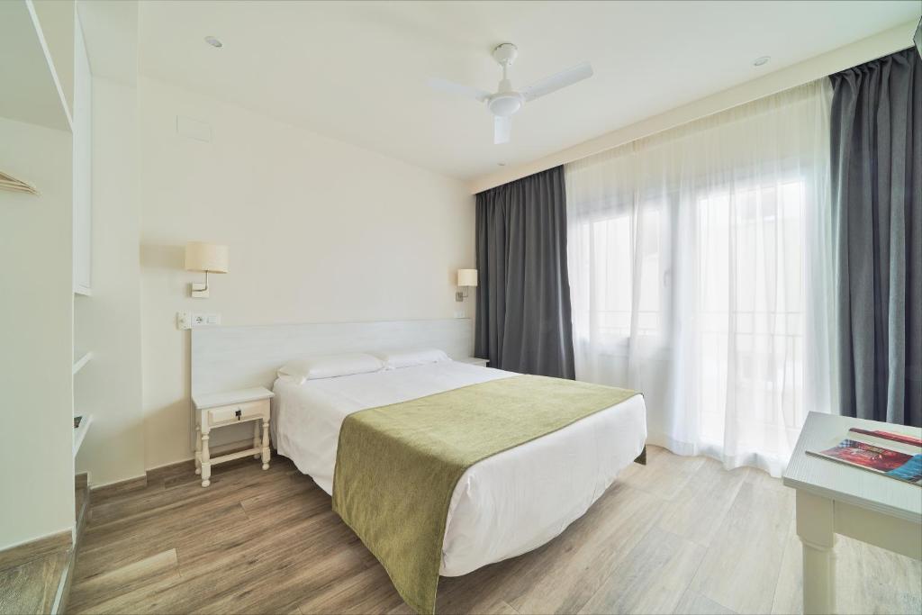um quarto de hotel com uma cama e uma janela em Hostal Sol y Miel em Benalmádena