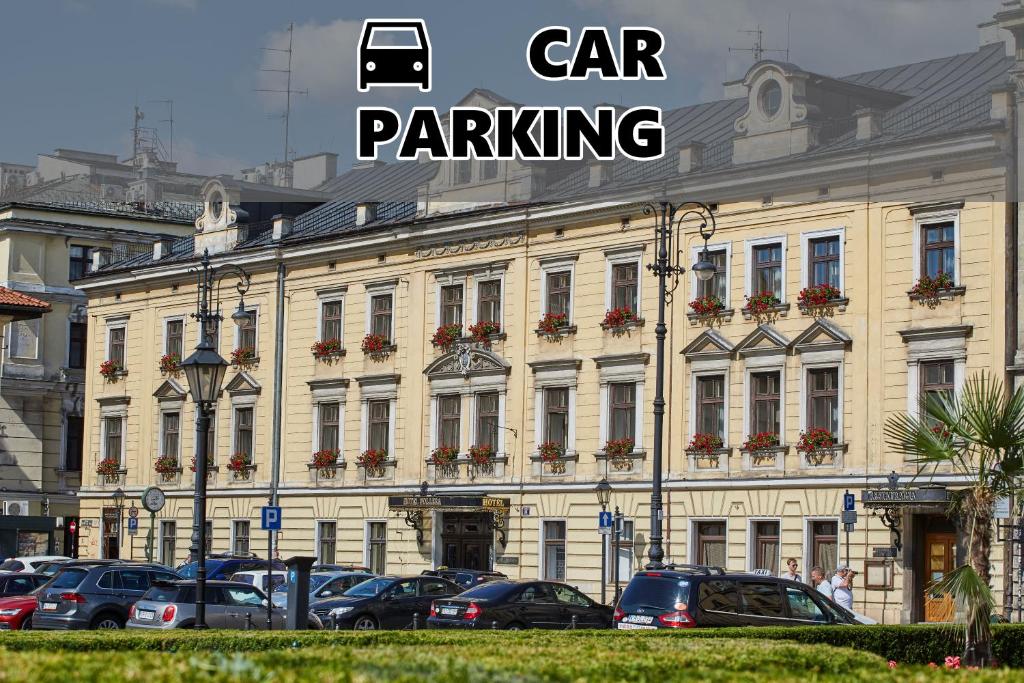 duży budynek z samochodami zaparkowanymi przed nim w obiekcie Pollera w Krakowie