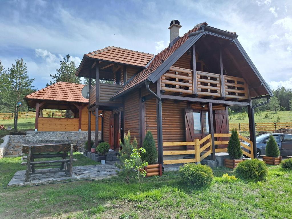 einem Blockhaus mit einer Bank davor in der Unterkunft Vila Vodice Zlatibor in Vodice