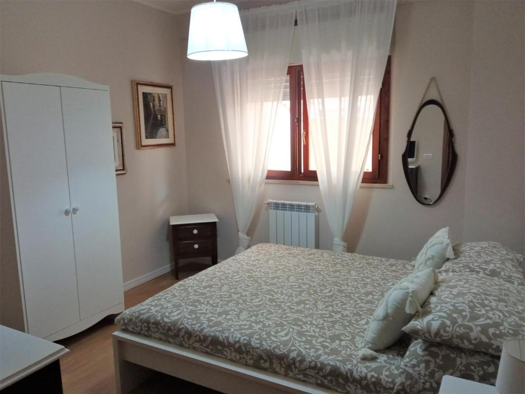 sypialnia z łóżkiem, komodą i lustrem w obiekcie as maison w mieście Terni