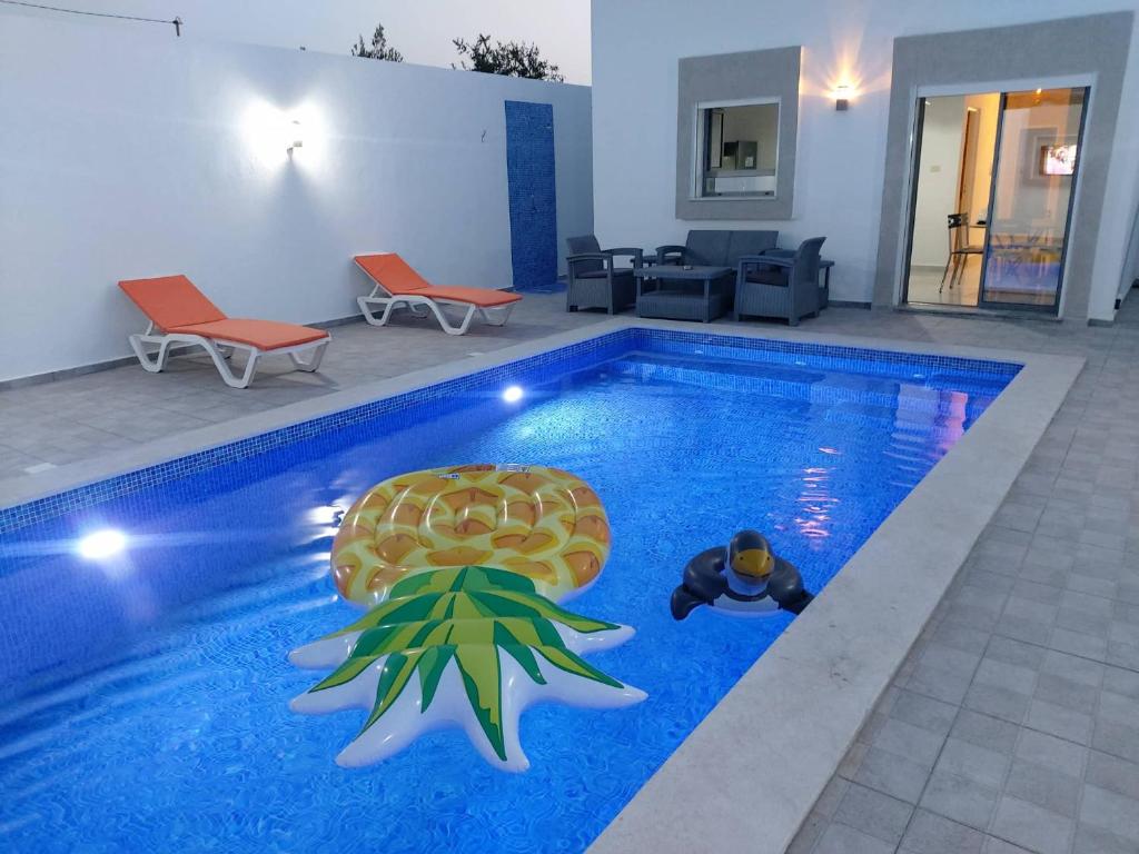 ein Pool mit einer Spielzeugschildkröte in der Mitte in der Unterkunft Villa LELLA HADHERYA in Taguermess