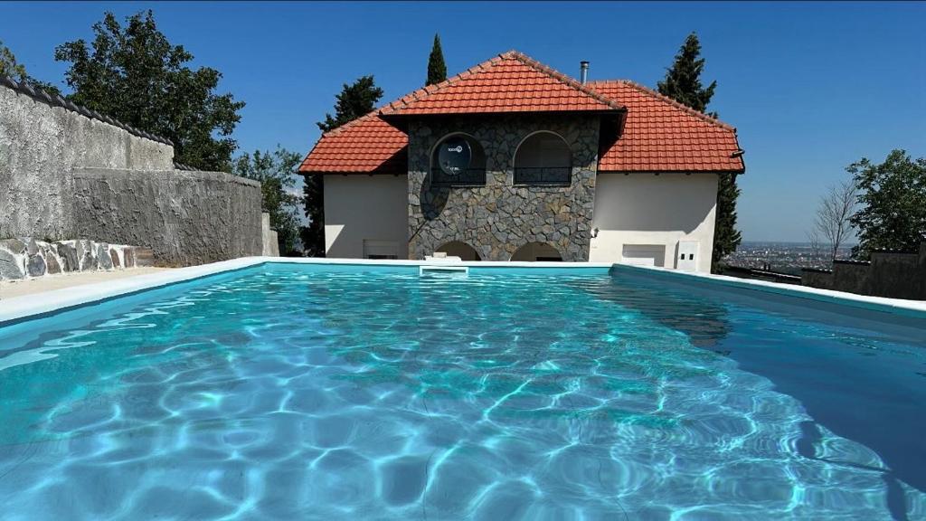 a villa with a swimming pool in front of a house at Vila ISKRA in Novi Sad