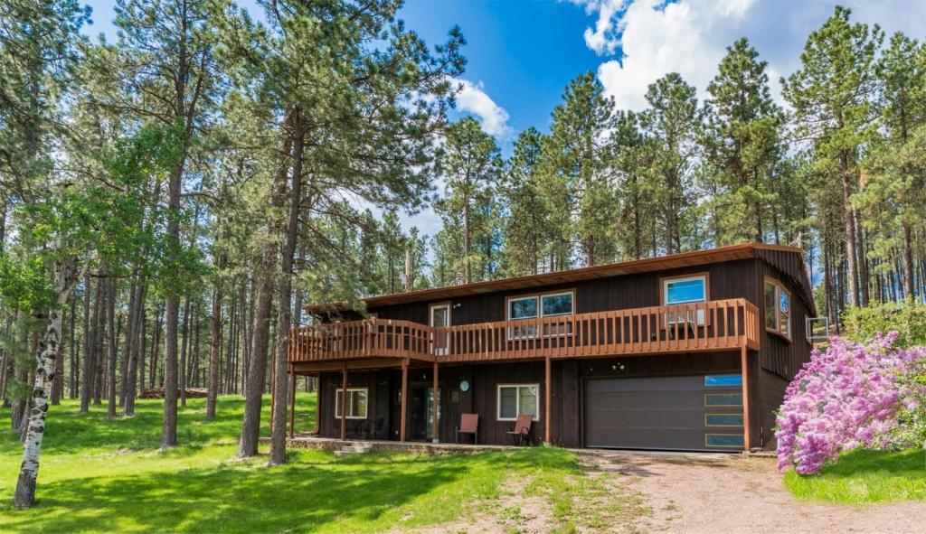 a house in the woods with a deck at Prairie Creek Cabin w/Hot tub in Rapid City
