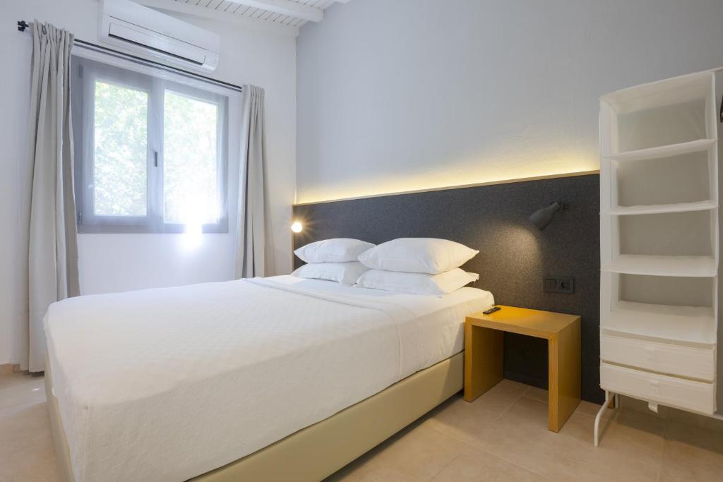 ein Schlafzimmer mit einem großen weißen Bett und einem Fenster in der Unterkunft AEGEAN Apartments - Bungalows in Alacati