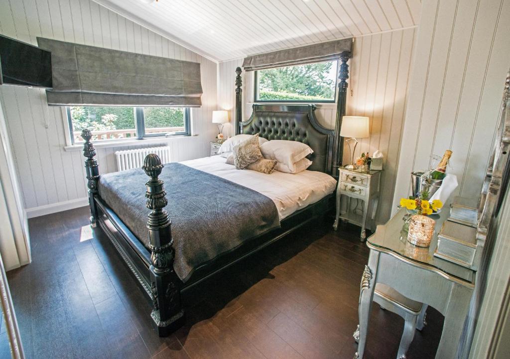 um quarto com uma cama grande e uma janela em Broadoaks Boutique Country House em Windermere