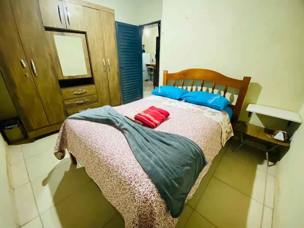 Una cama con almohadas azules y rojas. en Tranquilidade na Chapad dos Veadeiros, en Cavalcante