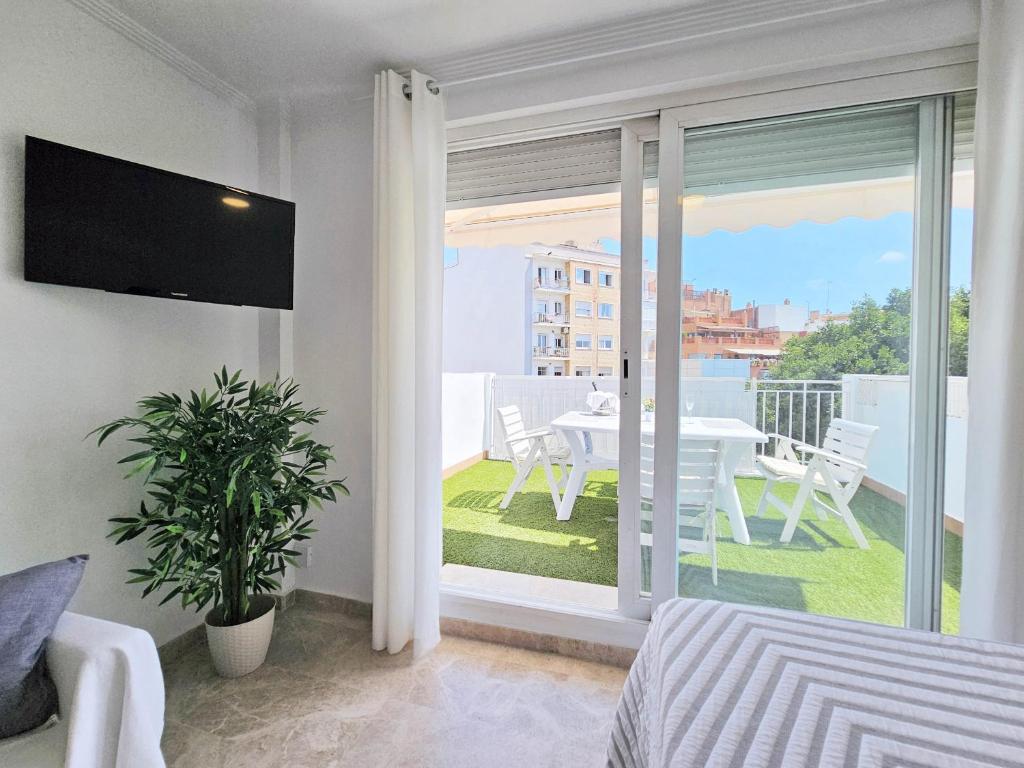 Schlafzimmer mit Blick auf einen Tisch und einen Balkon in der Unterkunft Atico Cartagena centro historico Parking in Cartagena