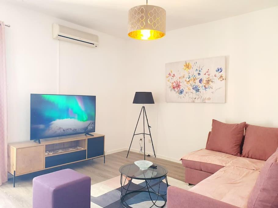 a living room with a couch and a flat screen tv at Apartman Sanja in Kostrena