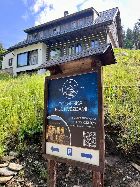 a sign in front of a house on a hill at Roubenka Pod hvězdami in Strážné
