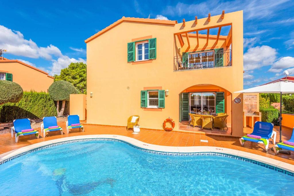 uma villa com piscina em frente a uma casa em Villa Marcolis Playa em Cala Galdana