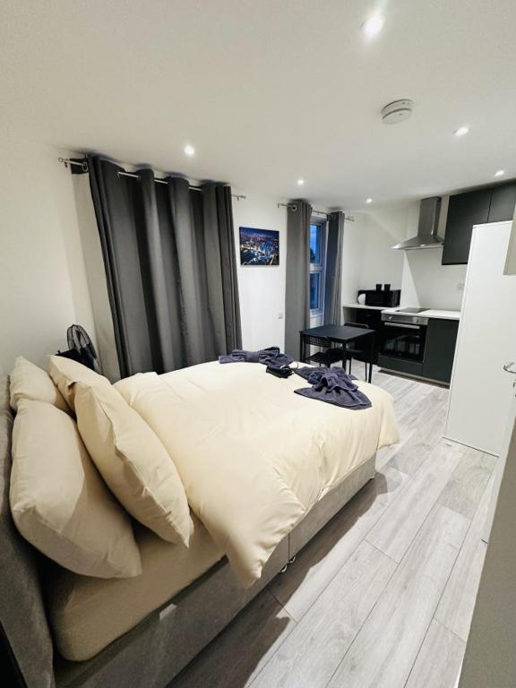 a bedroom with a large bed and a kitchen at Studio in Oval London in Bellaghy