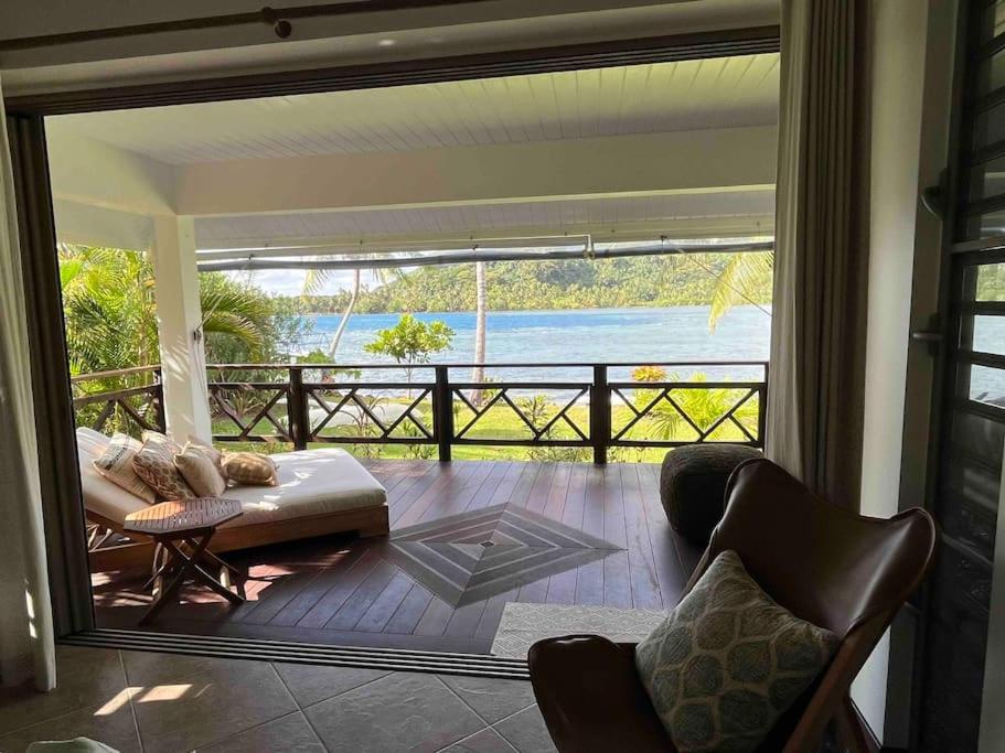 a living room with a view of the ocean at Blue Coral House, Luxury Waterfront in Maroe