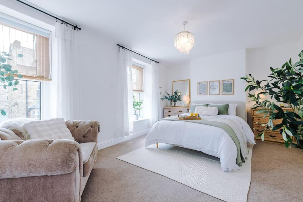 ein weißes Schlafzimmer mit einem Bett und einer Couch in der Unterkunft Rufloreo Dale - homely and central in Buxton