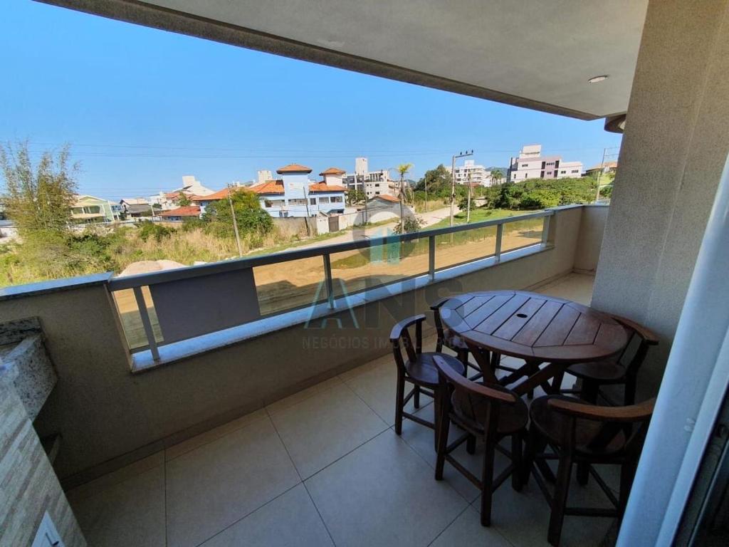 a balcony with a table and chairs and a view of the ocean at ANSNEGOCIOS APTO CHARMOSO PRAIA MARISCAL 101 Italy in Canto Grande