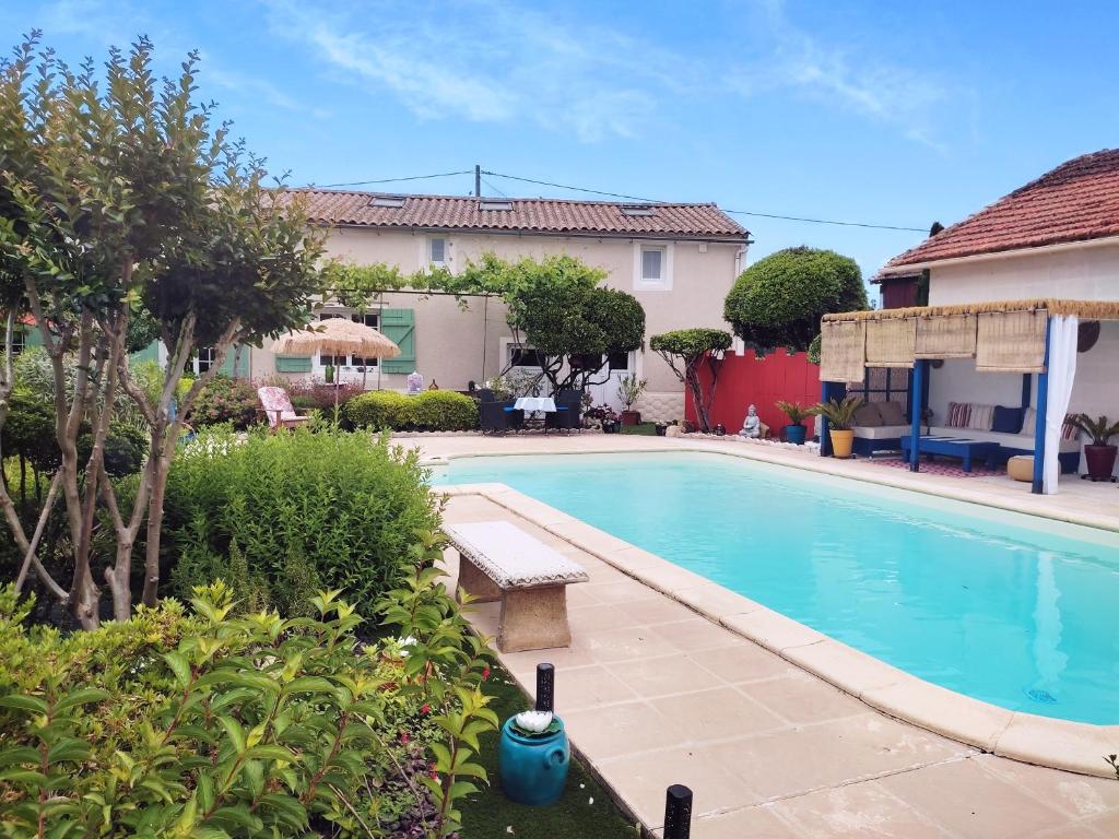 une piscine avec un banc à côté d'une maison dans l'établissement chaivero, à Pineuilh
