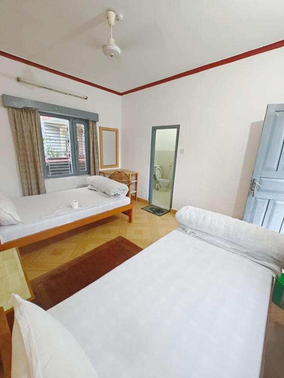 博卡拉Hotel Mountain View - Lakeside Pokhara的客房设有两张床和浴缸。
