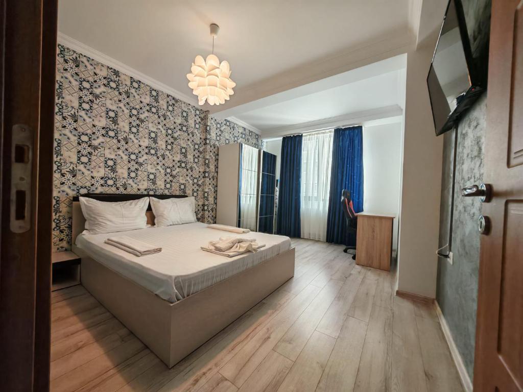 a bedroom with a bed and a chandelier at Apartments in Solid House Mamaia in Mamaia