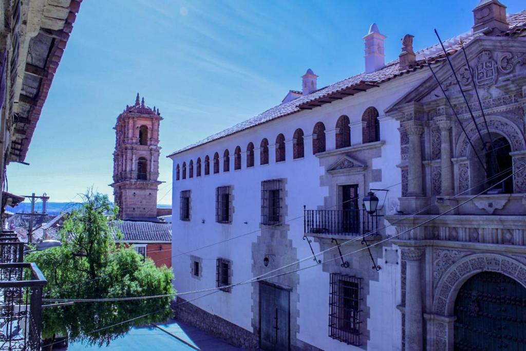 un vieux bâtiment avec une tour d'horloge dans une ville dans l'établissement Hostal La Realeza, à Potosí