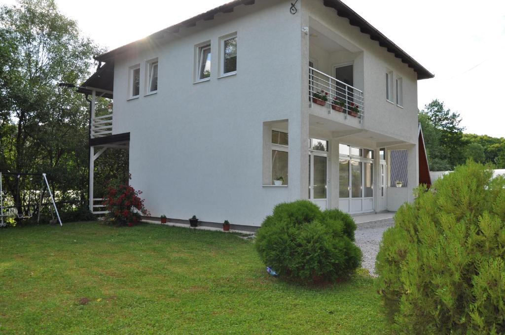 une grande maison blanche avec une cour dans l'établissement Nadia's home, à Ilidža
