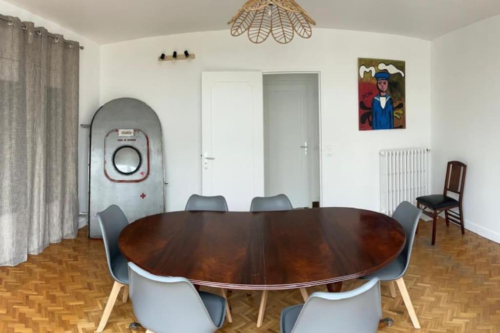 a dining room with a wooden table and chairs at Maison historique familiale 300m de la mer Sword Beach in Ouistreham