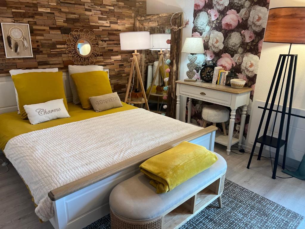 1 dormitorio con cama con almohadas amarillas y escritorio en Petit cocon proche de Stanislas, en Nancy